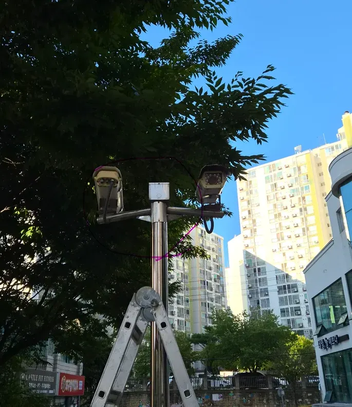 수리한 공장 출입구 CCTV 기둥과 카메라 두 대